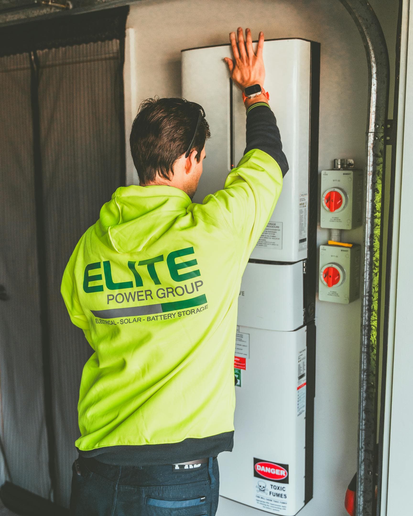 Techniker installiert einen Heimspeicher mit Wechselrichter im Hauswirtschaftsraum