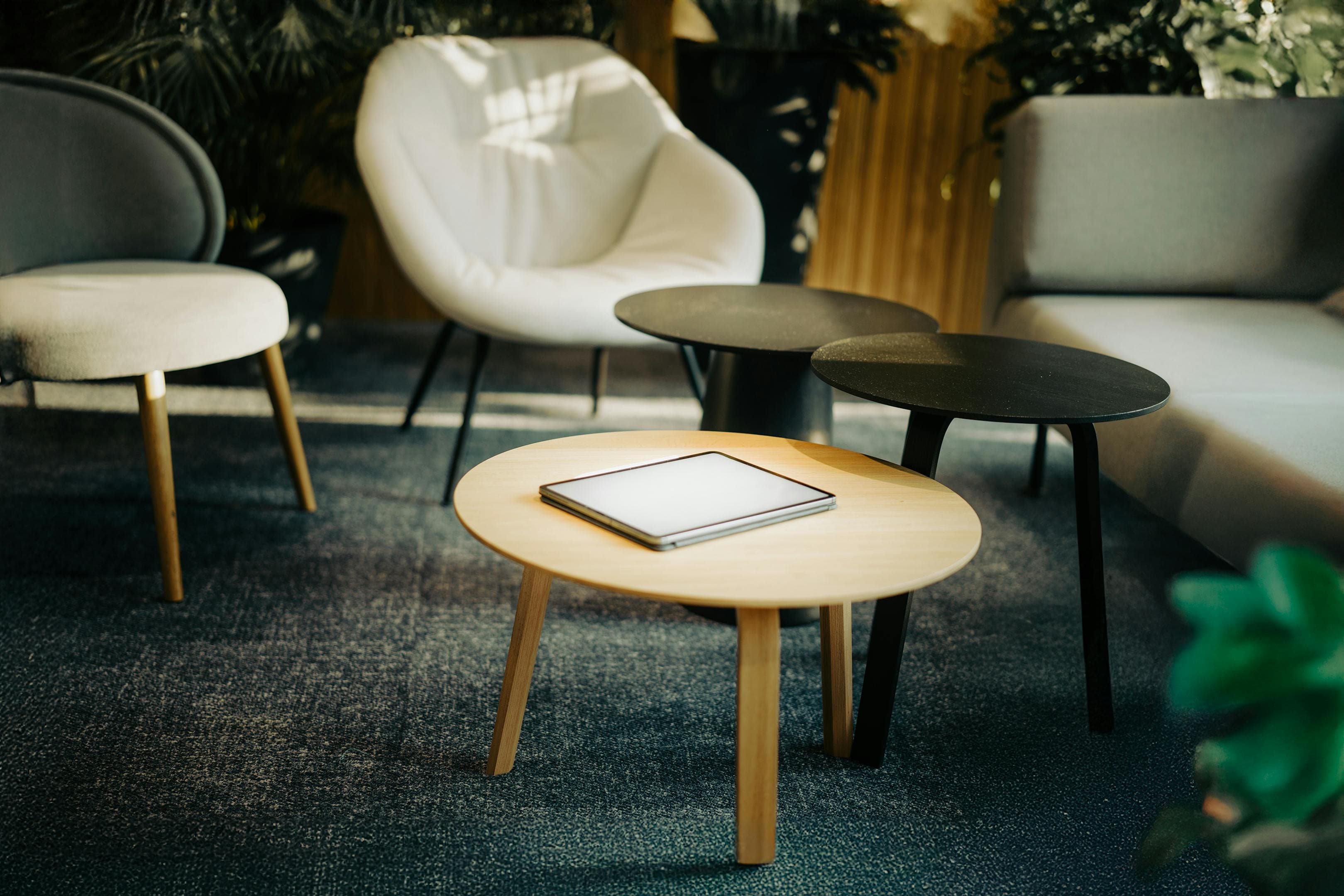 Modernes Wohnzimmer mit Tablet auf dem Couchtisch als Smart-Home-Schaltzentrale